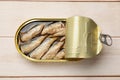 Tasty sprats in tin can on wooden table, top view Royalty Free Stock Photo