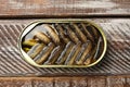 Tasty sprats in tin can on wooden table, top view Royalty Free Stock Photo