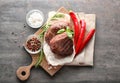Tasty steaks with chili peppers and herbs on board Royalty Free Stock Photo