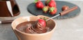 Tasty strawberry dipped into chocolate fondue on table, closeup. Banner design Royalty Free Stock Photo