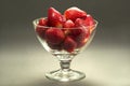 Strawberries in a glass cup on a gray background, studio