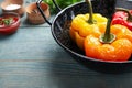 Tasty stuffed bell peppers in baking dish on blue wooden table, closeup Royalty Free Stock Photo