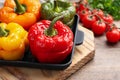 Tasty stuffed bell peppers in baking pan on wooden table, closeup Royalty Free Stock Photo