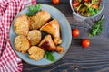 Tasty stuffed chicken legs with salad of fresh vegetables on a wooden background Royalty Free Stock Photo