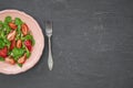 Tasty summer salad with strawberry, fork cutlery and space for text, copy space, black marble background, top view