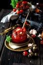 Tasty sun dried tomatoes with garlic, pepper, basil, olive oil in glass jar stands on brass plates on rustic wooden table Royalty Free Stock Photo