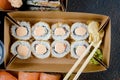 Tasty sushi rolls in disposable kraft paper boxes, sauces, chopsticks. Food for take away or delivery Royalty Free Stock Photo