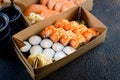 Tasty sushi rolls in disposable kraft paper boxes, sauces, chopsticks. Food for take away or delivery Royalty Free Stock Photo