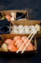 Tasty sushi rolls in disposable kraft paper boxes, sauces, chopsticks. Sushi for take away or delivery