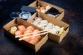 Tasty sushi rolls in disposable kraft paper boxes, sauces, chopsticks. Sushi for take away or delivery