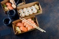 Tasty sushi rolls in disposable kraft paper boxes, sauces, chopsticks. Sushi for take away or delivery