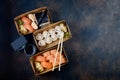 Tasty sushi rolls in disposable kraft paper boxes, sauces, chopsticks. Sushi for take away or delivery
