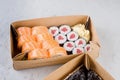 Tasty sushi rolls in disposable kraft paper boxes, sauces, chopsticks. Sushi for take away or delivery Royalty Free Stock Photo