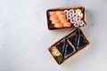 Tasty sushi rolls in disposable kraft paper boxes, sauces, chopsticks. Sushi for take away or delivery Royalty Free Stock Photo