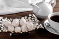 Tasty sweet coconut candies in a vase with tea on a brown wooden table Royalty Free Stock Photo