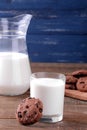 Tasty sweet cookies with chocolate and milk on a brown wooden table and on a blue background Royalty Free Stock Photo