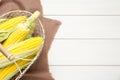 Tasty sweet corn cobs in metal basket on white wooden table, top view. Space for text Royalty Free Stock Photo