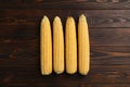 Tasty sweet corn cobs on wooden table, flat lay Royalty Free Stock Photo
