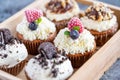 Tasty sweet muffins with mascarpone creme and chocolate, raspberry and blueberry. Fresh home baked sweets with fruit. Placed in Royalty Free Stock Photo