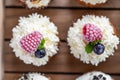 Tasty sweet muffins with mascarpone creme and chocolate, raspberry and blueberry. Fresh home baked sweets with fruit. Placed in Royalty Free Stock Photo