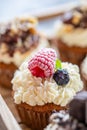 Tasty sweet muffins with mascarpone creme and chocolate, raspberry and blueberry. Fresh home baked sweets with fruit. Placed in Royalty Free Stock Photo