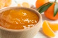 Tasty tangerine jam in wooden bowl on white table  closeup Royalty Free Stock Photo