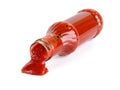 Tasty thick tomato ketchup slowly flows out of a glass bottle lying on its side isolated on a white background. Spices, seasonings Royalty Free Stock Photo
