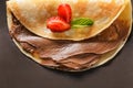Tasty thin pancakes with chocolate spread and strawberries on dark background, closeup Royalty Free Stock Photo