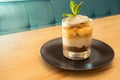 Tasty tiramisu on glass with mint on bistro table