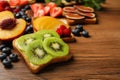 Tasty toast with butter and kiwi slices on wooden table, closeup. Space for text Royalty Free Stock Photo