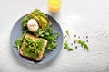 Tasty toasts with avocado and egg Benedict on plate