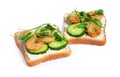 Tasty toasts with cream cheese, shrimps, cucumbers and microgreens on white background