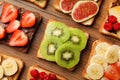 Tasty toasts with different spreads and fruits on wooden table, flat lay Royalty Free Stock Photo