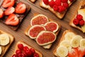 Tasty toasts with different spreads and fruits on wooden table, flat lay Royalty Free Stock Photo