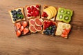 Tasty toasts with different spreads and fruits on wooden table, flat lay Royalty Free Stock Photo