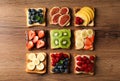 Tasty toasts with different spreads and fruits on wooden table, flat lay Royalty Free Stock Photo