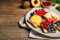 Tasty toasts with different spreads and fruits on wooden table. Space for text Royalty Free Stock Photo