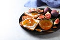 Tasty toasts with fig jam and cream cheese on grey marble table, closeup