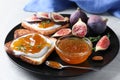 Tasty toasts with fig jam and cream cheese on grey table, closeup