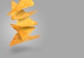 Tasty tortilla chips falling on grey background Royalty Free Stock Photo