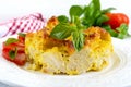 Tasty useful casserole from cauliflower on a plate on a white wooden background.