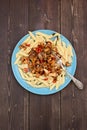 Tasty vegetarian meal. Pasta penne with wild chanterelle mushrooms and chili pepper in blue plate on dark wooden background Royalty Free Stock Photo