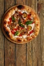 Tasty vegetarian pizza with vegetables, tomato souse, paper, cheese, herbs and basil. Traditional italy food on wooden