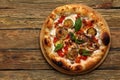 Tasty vegetarian pizza with vegetables, tomato souse, paper, cheese, herbs and basil. Traditional italy food on wooden