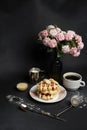 Tasty Waffles Plate, Caramel Sauce, Coffee Cup, Milk, dessertspoon, strainer, pink flowers Royalty Free Stock Photo