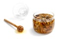 Tasty walnut with honey in a glass jar on a white  background. Nearby lies a spoon with dripping honey and a glass lid Royalty Free Stock Photo