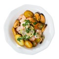 Tasty warm salad with fried potatoes, shrimp and mussels, served at plate Royalty Free Stock Photo