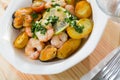 Tasty warm salad with fried potatoes, shrimp and mussels, served at plate Royalty Free Stock Photo