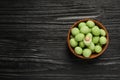 Tasty wasabi coated peanuts in bowl on black wooden table, top view. Space for text Royalty Free Stock Photo