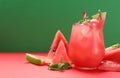 Tasty watermelon drink and fresh fruits on red table against green background. Space for text Royalty Free Stock Photo